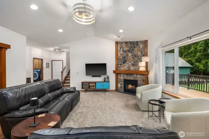 Spacious living area with high ceilings and an open layout connecting toward the entry, stairs, and adjacent living spaces while maintaining views toward the backyard.