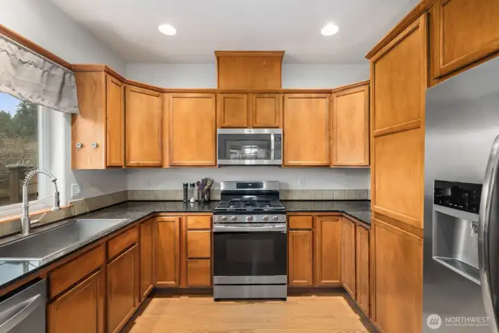 Functional kitchen with ample cabinet storage and stainless appliances, positioned conveniently beside the dining area for everyday cooking and gathering.