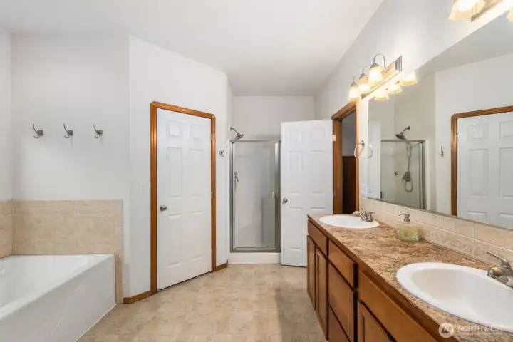 Primary bathroom with dual sinks, separate shower, and soaking tub, offering a spacious layout connected to the primary suite.