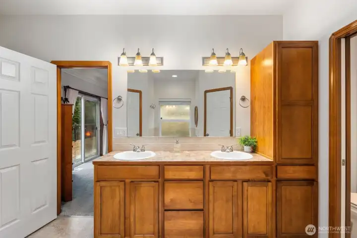 Primary bathroom with a wide double-sink vanity, large mirror, and overhead lighting, offering generous counter space and storage.