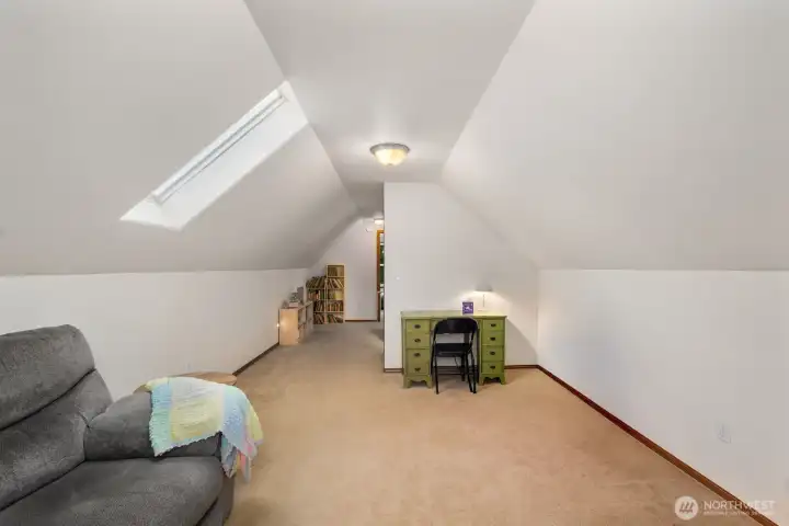 View of the upstairs bonus area showing a built-in workspace nook and shelving, offering a flexible area for reading, hobbies, or remote work.