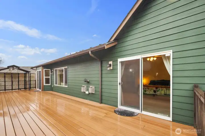 Large rear deck with sliding glass door access to the home, creating a seamless connection between indoor and outdoor living.