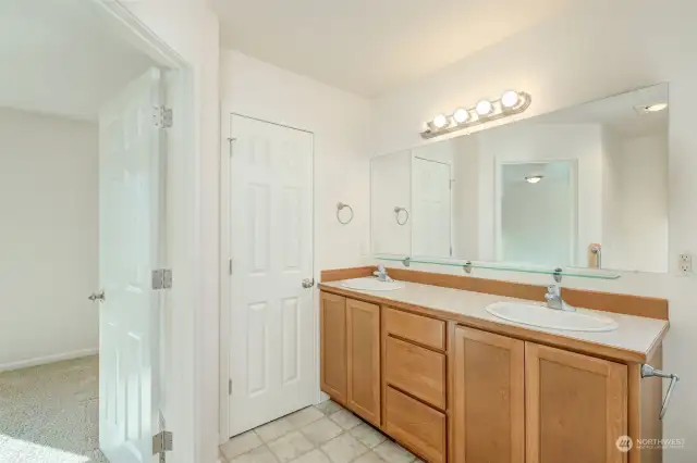 Primary bathroom with 2 sinks and the walk-in closet is straight ahead.