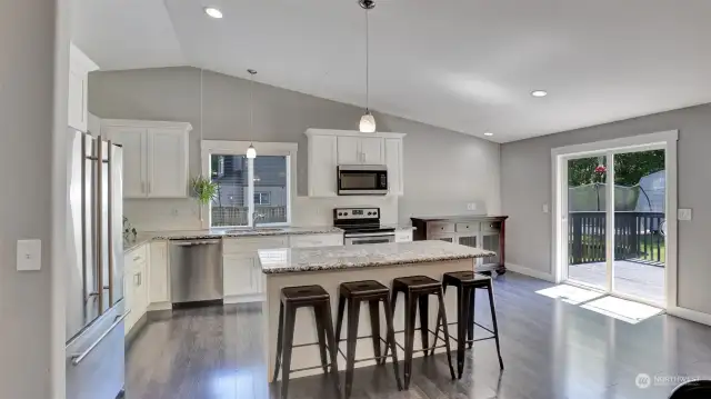 Kitchen has vaulted ceilings and recess lighting, sliding door opens to the large backyard.