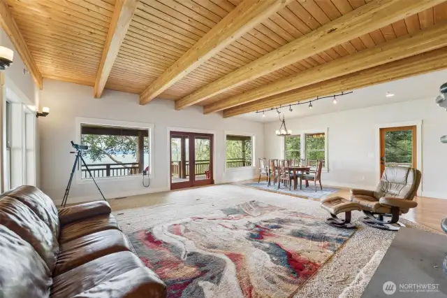 Open concept layout with wood beamed ceilings and large windows to bring in the view of Port Susan and the Cascade Mountains including Mt Baker.