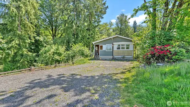 Another view shows the well established greenery and old growth trees around the home.