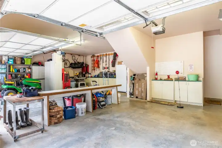 Tucked-in areas for tools and toys, benches and vehicles!  (More tool storage behind the camera)  Electric double garage door AND electric single garage door