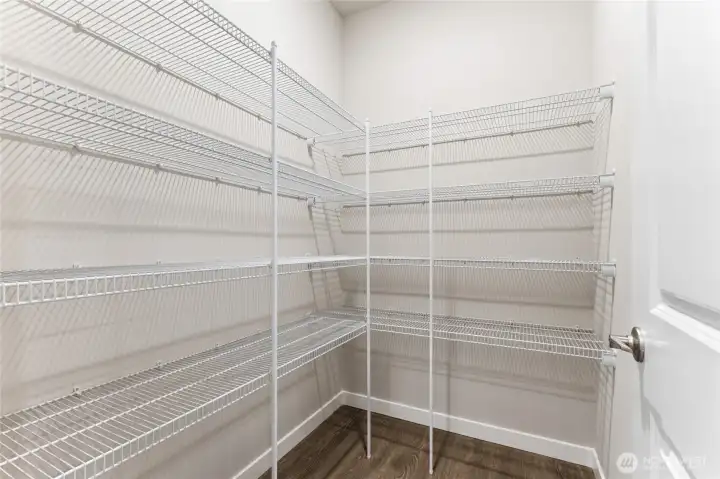 Walk-in pantry by garage entrance door.  Actual home is under construction and materials, colors, and finishes will vary. See site agent for details.