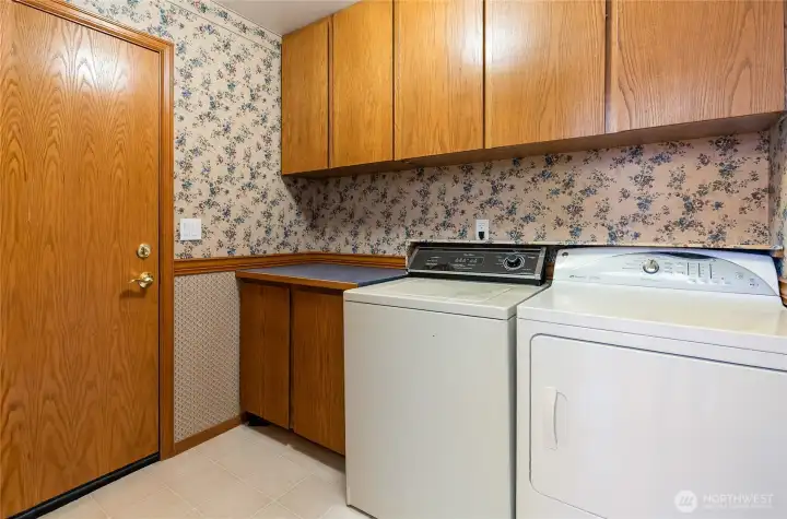 Laundry room / half bath with garage access door. Nice storage cupboards.