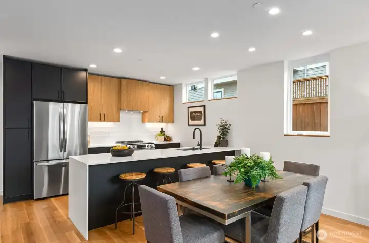 Chef's kitchen with a spacious island, custom cabinetry, SS appliances, under-cabinet lighting, and stylish backsplash.