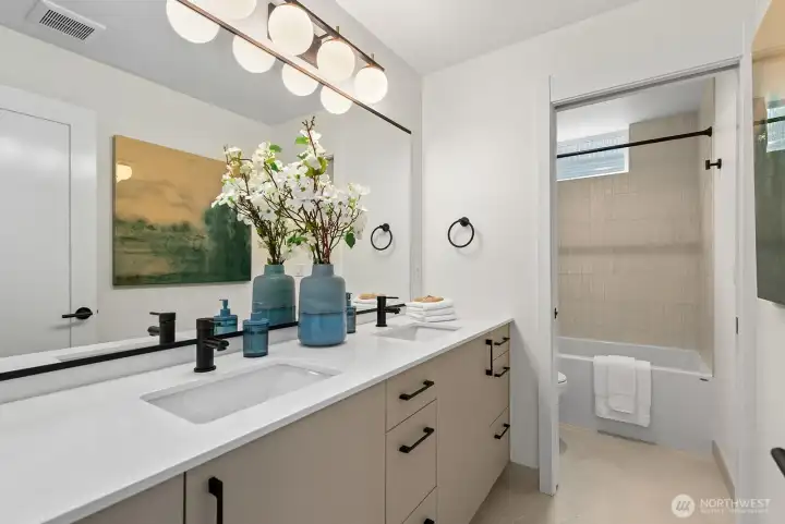 Well-appointed shared full bathroom with dual sinks.