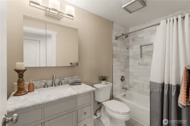 Updated main bath with marble tile shower, new vanity, and lighting. Updated main bath with marble tile shower, new vanity, and lighting.