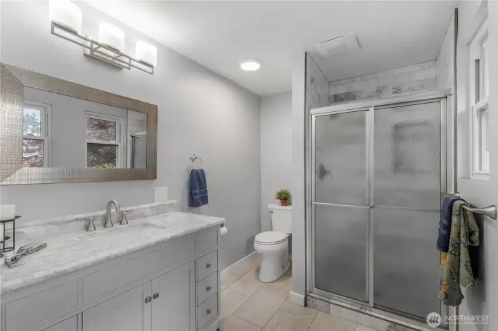 Three-quarter en-suite bath with marble tile shower and porcelain flooring. New vanity and lighting. Three-quarter en-suite bath with marble tile shower and porcelain flooring. New vanity and lighting.
