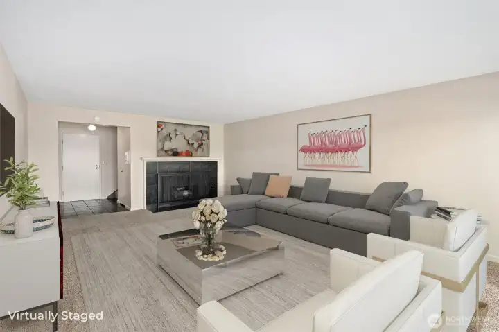 Another perspective of the living room showcases the inviting gas fireplace as a warm focal point, with the entryway just beyond, adding to the home’s open and welcoming flow.