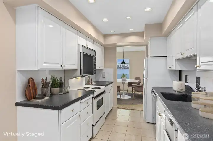 The light and bright kitchen showcases crisp white cabinetry paired with updated countertops, creating a clean, modern feel that is both stylish and functional.