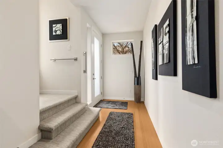Inviting entryway with bamboo floors and natural light from the oversized front door.