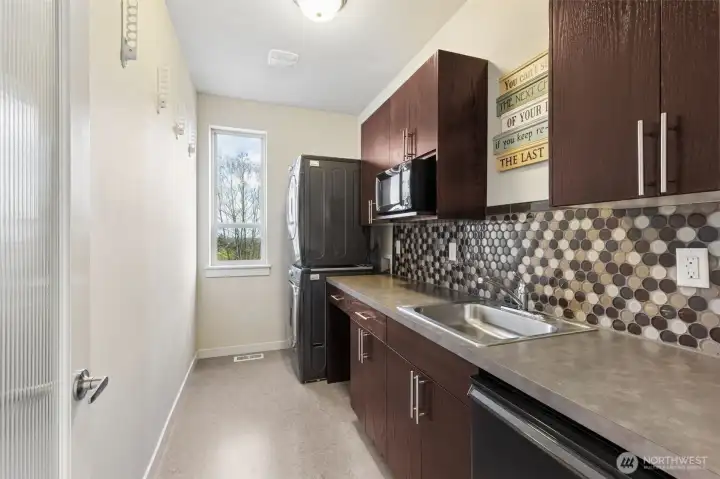 The utility room has been transformed for best use of space. Long countertop, extra cabinetry for storage and a mini-kitchen with sink, fridge and microwave. Very convenient for the bedroom suite on this floor!