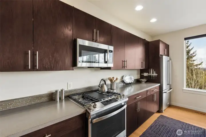 Newer stainless steel appliances, including a gas range oven.