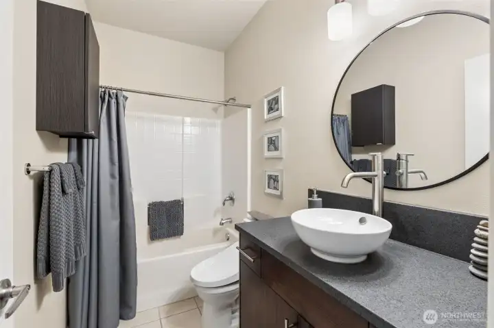 Full bathroom, conveniently located just off of the main living space and next to the third bedroom. Stylish vessel sink and granite countertops in here.
