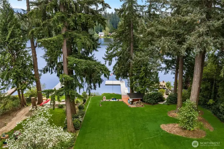 Large manicured yard leading from house to lake front patio, dock and tiki bar. Large manicured yard leading from house to lake front patio, dock and tiki bar.