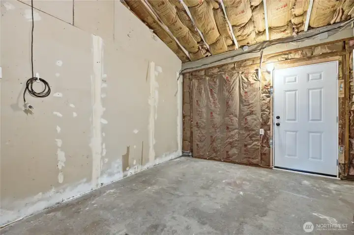 Garage with access door to front of home. Header still in place to add a garage door back on.