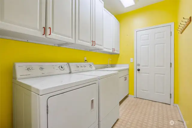 Laundry room with garage access, includes utility sink and built-in storage. Washer & Dryer included!