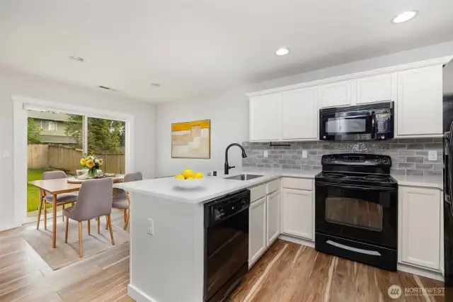 The kitchen and dining area are subtly separated, providing a perfect balance of openness and defined space for both cooking and dining. - Virtually Staged