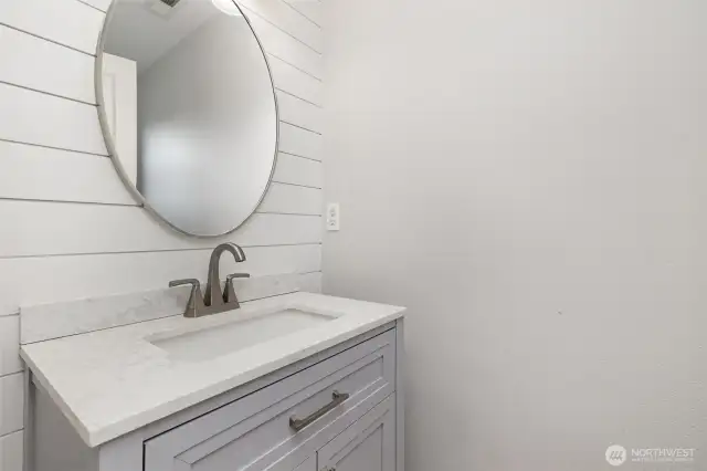 Bright and crisp main floor half bath, conveniently located off the living room for easy access and guest convenience.