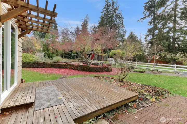 View from back deck (back secondary bedroom) facing the backyard: to your left is the raised garden bed area and to the right is the firepit and chicken coupe. Property behind white fence is the enclosed pasture.