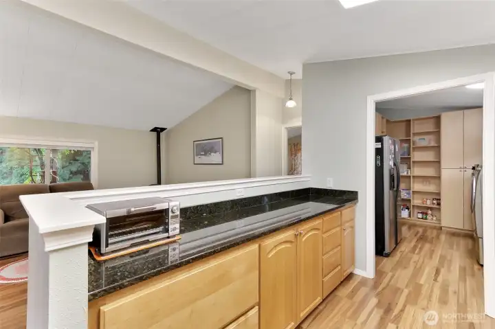 Updated kitchen has soft close drawers and cabinets with pull out shelves for convenient access. Notice to your right, thru the kitchen, a custom designed, oversized walk in pantry with refrigerator, washer and dryer that all stay.