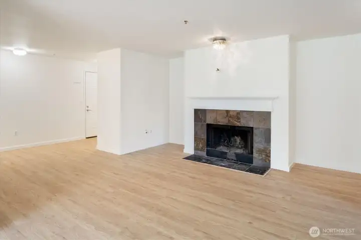 The living room is bright, warm, and welcoming: natural light and a wood burning fireplace ensure seasonless comfort.