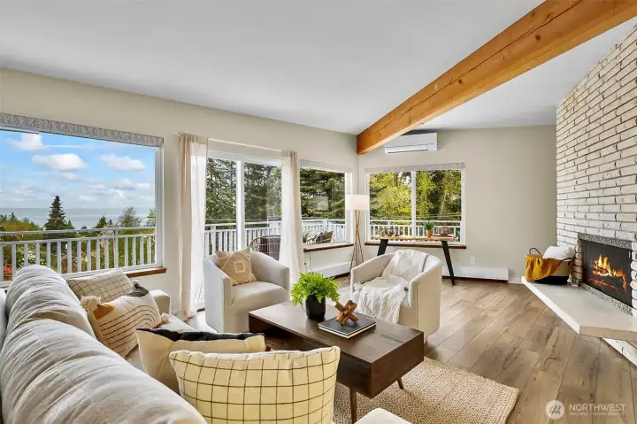 This Inviting Living Space Features Expansive Windows, Warm Wood Tones And A Stunning Brick Fireplace. The Exposed Beam Adds Just The Right Touch Of Character.