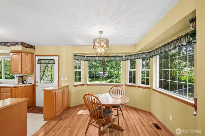 Dining area features same wood-laminate floors & large windows for natural light,