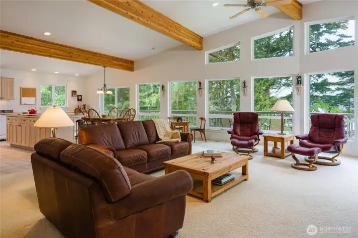 Great room with beamed, vaulted ceiling and wall of windows to showcase the Island & Channel views.