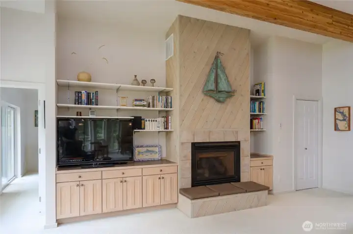 Propane fireplace along side bookshelves and cabinets.  Door to the left goes to the primary suite.
