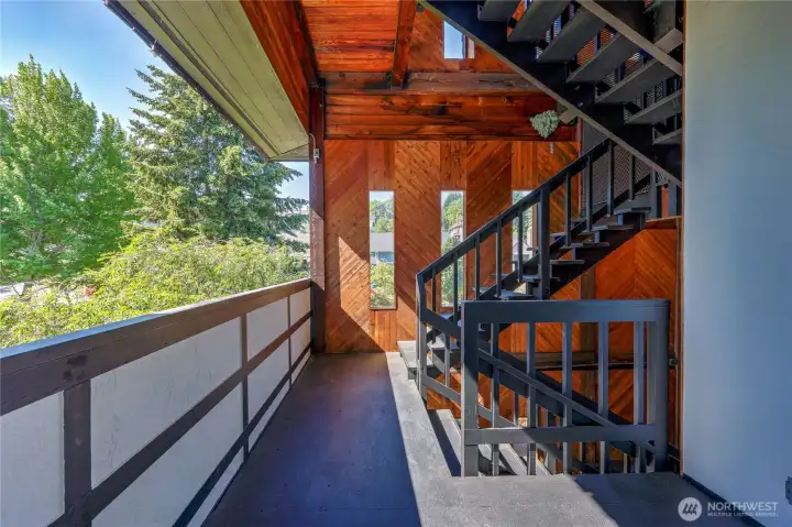 One flight of stairs in a well-lit entrance. Open-air yet private.
