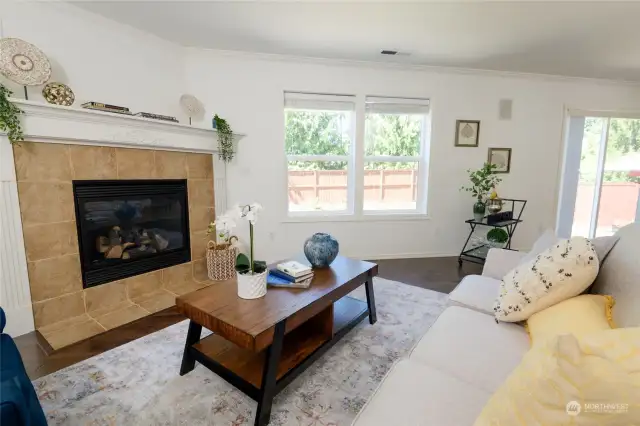 The fireplace adds a touch of elegance, while the comfortable layout provides plenty of room for seating and entertainment. Large windows provide views out to the private, fully-fenced back yard.