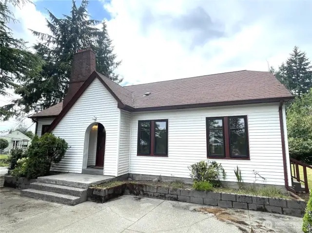 A graceful sloping gabled room leads to an inviting arched entry to the vestibule. Vinyl siding makes for low maintenance.