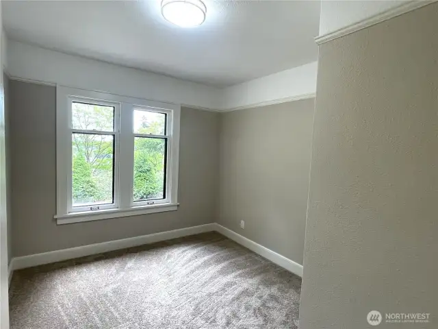 The primary bedroom features two windows looking towards Mt. Rainier and the Cascades. New carpet, trim and lighting with fresh paint throughout.