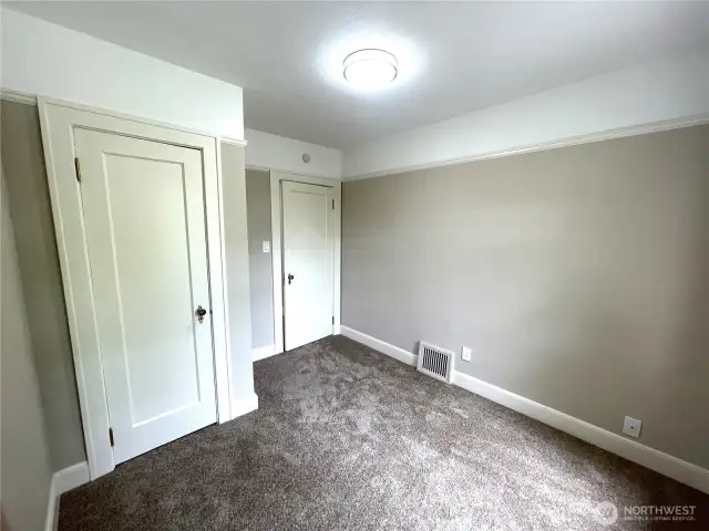 Bedroom number 2 showing the closet door and the entry door. All new carpet, lighting and paint.