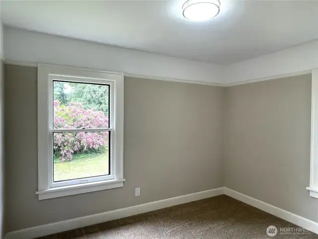 Bedroom number three has two expansive windows that look out to the beautiful flowering mature plantings.
