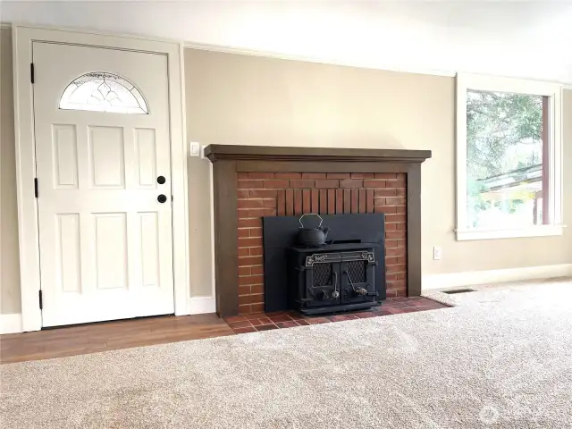 Upon entry to the living room, you are greeted with this attractive wood stove and brick fireplace. The wood mantle and side boards give it an updated look.