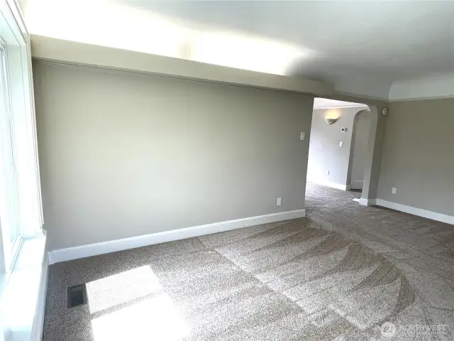 Hidden lighting at the crown of the living room wall. Arched entryway into the hallway. Coved ceilings are a feature of this house.