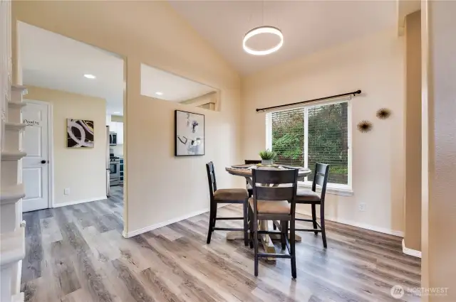 Vaulted ceilings continue through dining room, with view to the mature landscaping