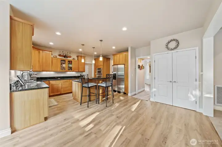 Kitchen features eating bar, stainless steel appliances, beautiful hardwood floors, and large pantry.
