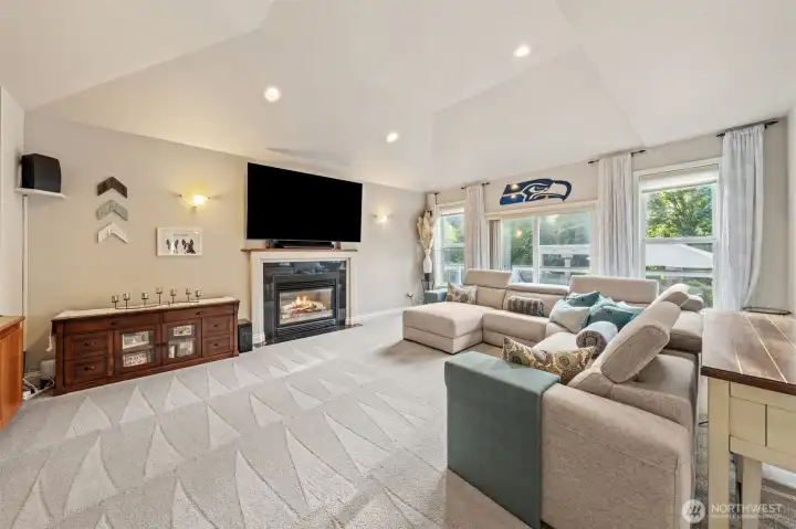 Family room with gas fireplace, vaulted ceilings and large windows providng an abundance of natural light.