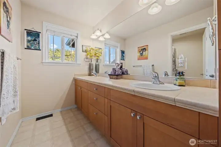 Main bathroom with double sinks and bathtub.