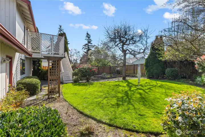 Fully fenced backyard with lawn, mature landscaping, and garden space—ideal for outdoor enjoyment, pets, or entertaining.