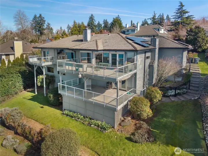 Rear exterior highlights expansive deck living and energy-conscious solar installation.