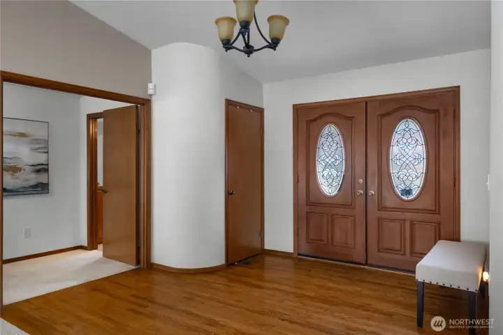 Grand double-door entry welcomes you with warmth, natural light, and hardwood flooring.